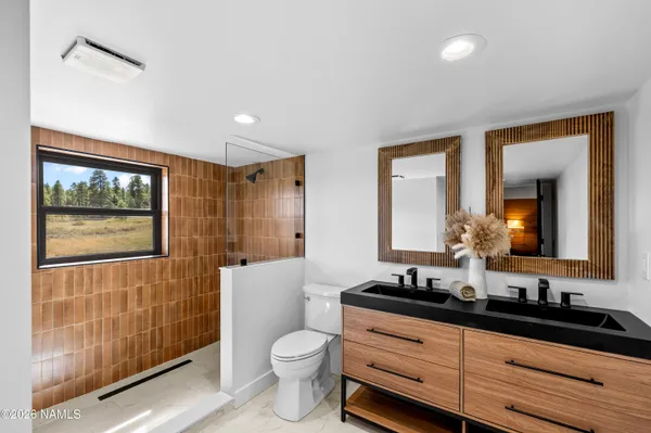 a bathroom with a double vanity sink toilet and shower