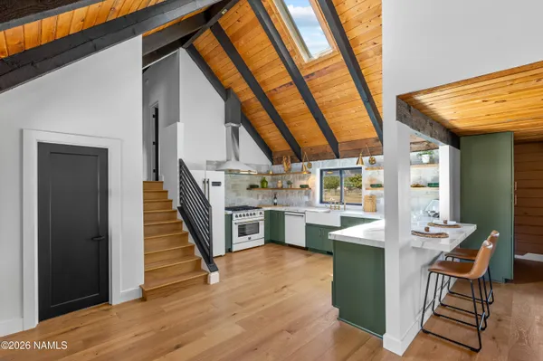 a open kitchen with white cabinets and wooden floor