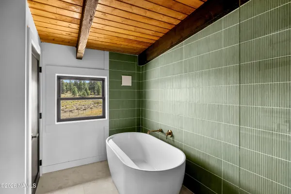 a bathroom with a granite countertop sink a toilet a mirror and shower
