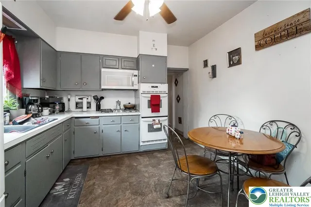 a kitchen with a dining table chairs sink and stove