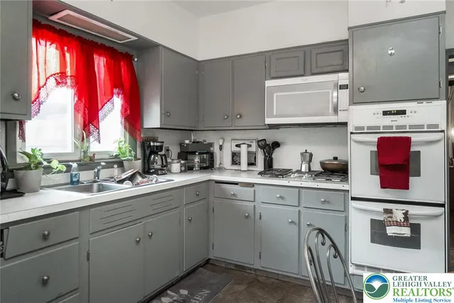 a kitchen with stainless steel appliances granite countertop a sink a window and cabinets