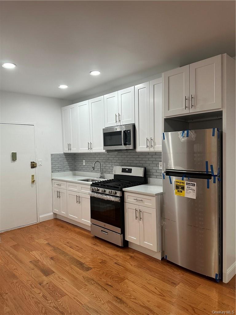 a kitchen with granite countertop a refrigerator stove and microwave