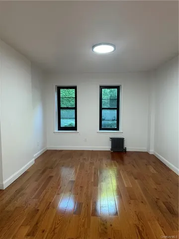 a view of a room with wooden floor and window