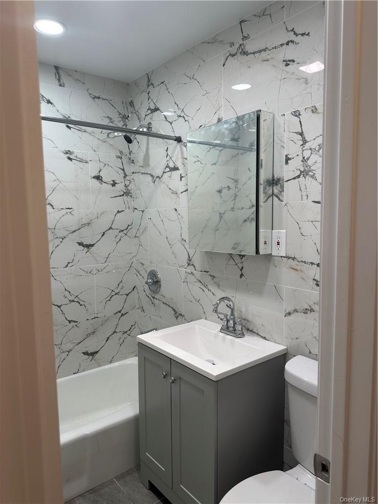 145-149 Morningside Avenue, Unit 2C Manhattan, NY 10027 - Photo 8 of 12 a bathroom with a sink mirror and a bathtub