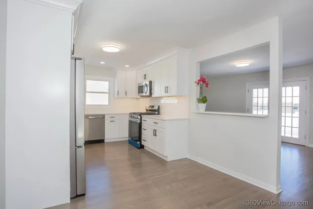 a kitchen with white cabinets and white appliances