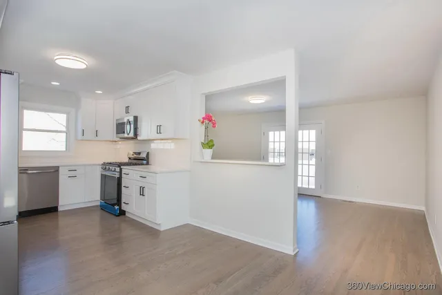 a kitchen with a refrigerator and a stove top oven