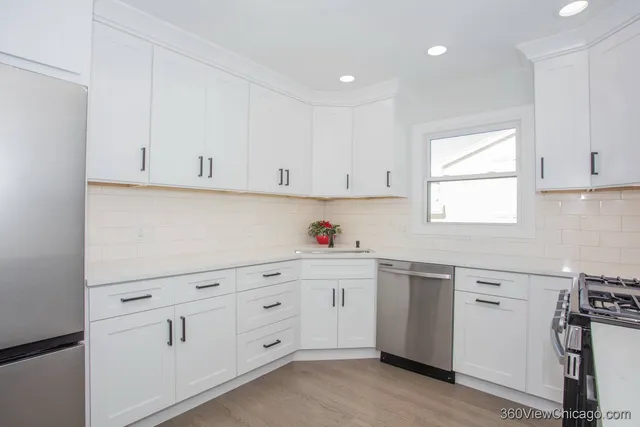 a kitchen with white cabinets and white appliances