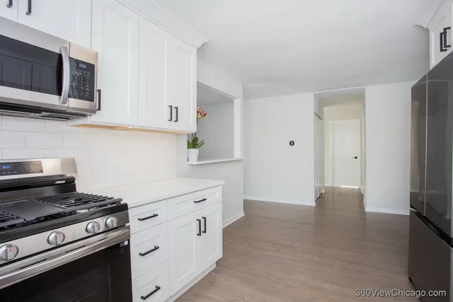 a kitchen with stainless steel appliances a stove microwave and refrigerator