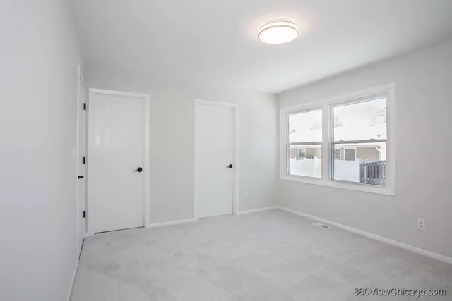 an empty room with windows and closet