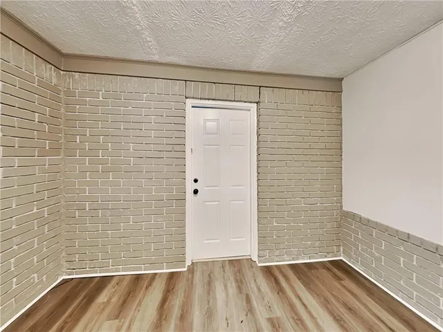 a view of a room with wooden floor and brick walls