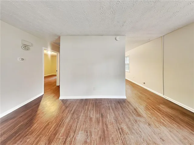 a view of a big room with wooden floor and windows