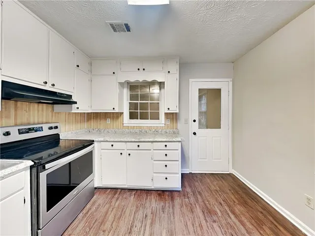 a kitchen with granite countertop a stove and cabinets