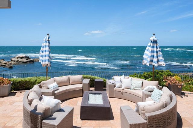 a roof deck with couches and ocean view