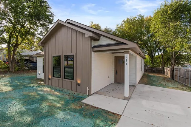 a view of a small house with backyard