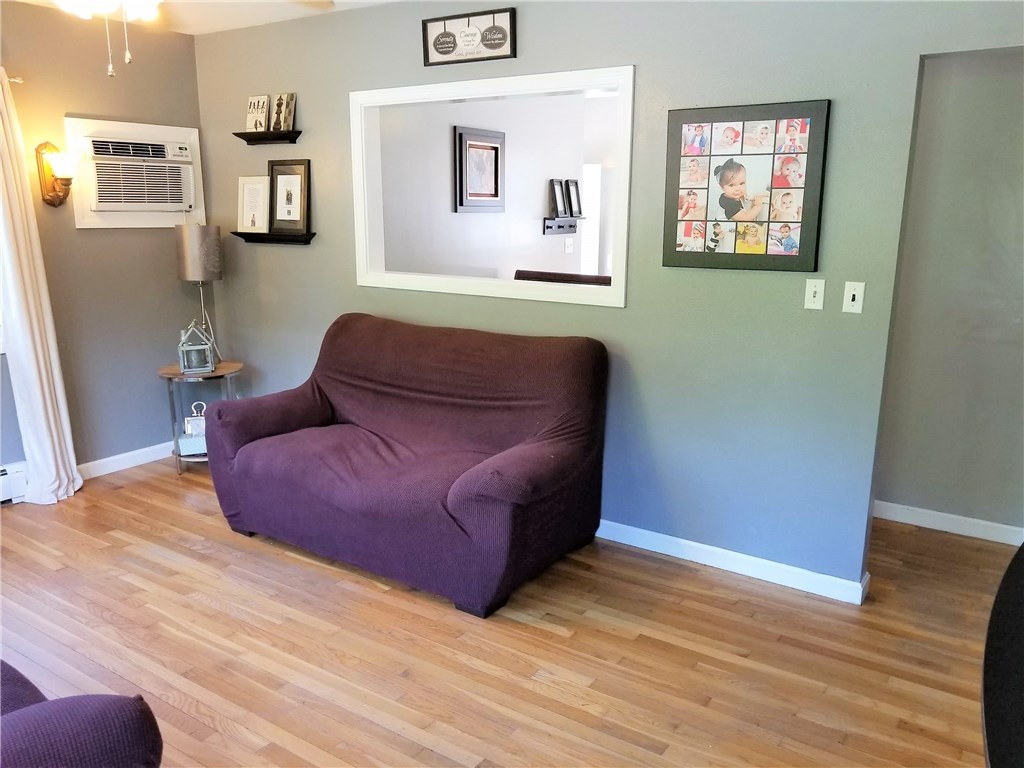 79 Restful Valley Road Tiverton, RI 02878 - Photo 8 of 18 family room with lots of light, built in AC unit, and hardwood floors