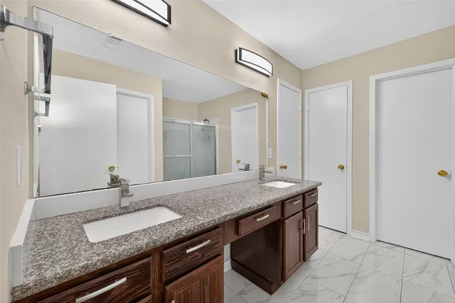 a bathroom with a granite countertop sink and a mirror