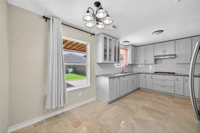 a kitchen with stainless steel appliances granite countertop a stove a sink and a refrigerator