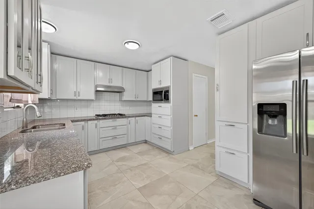 a large kitchen with white cabinets