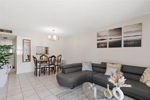 a living room with furniture a dining table and kitchen view