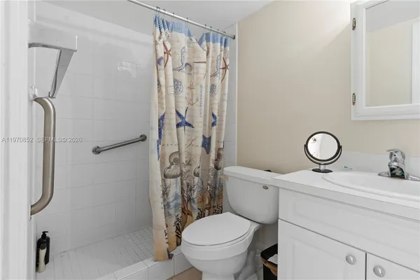 a bathroom with a toilet sink vanity and shower