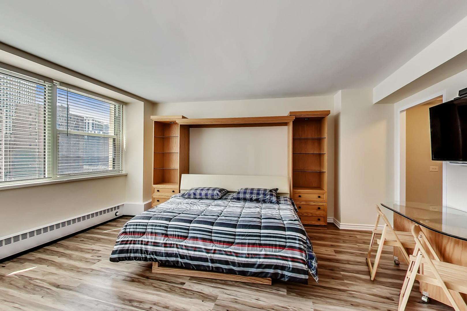 1150 North Lake Shore Drive, Unit 11J Chicago, IL 60611 - Photo 13 of 34 a bedroom with a bed and wooden floor