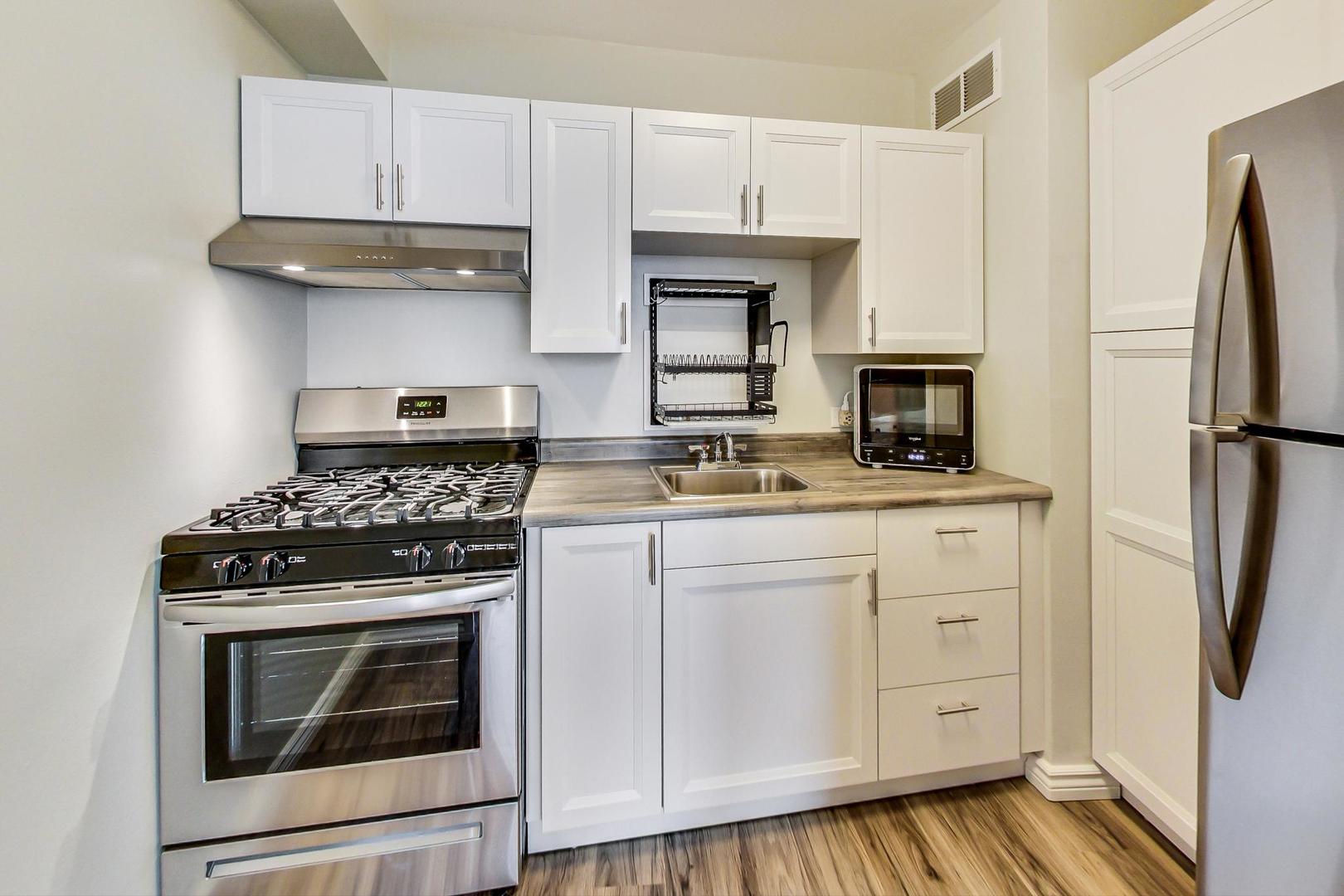 1150 North Lake Shore Drive, Unit 11J Chicago, IL 60611 - Photo 18 of 34 a kitchen with white cabinets and appliances