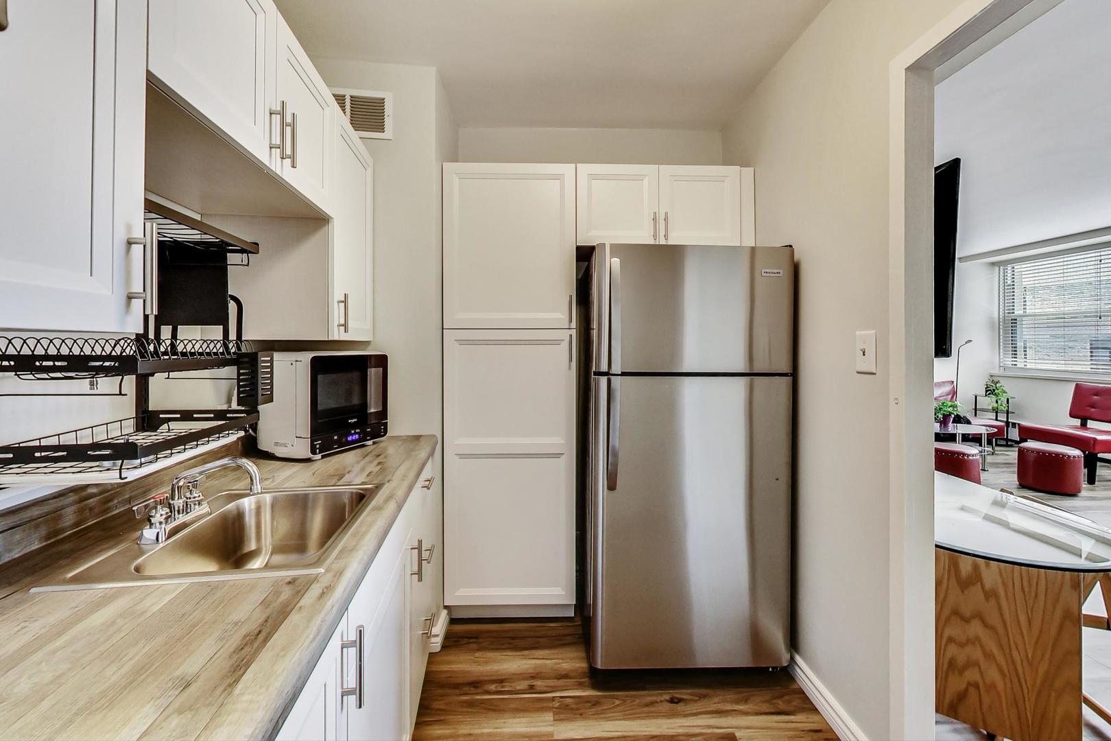 1150 North Lake Shore Drive, Unit 11J Chicago, IL 60611 - Photo 19 of 34 a kitchen with stainless steel appliances granite countertop a refrigerator and a sink
