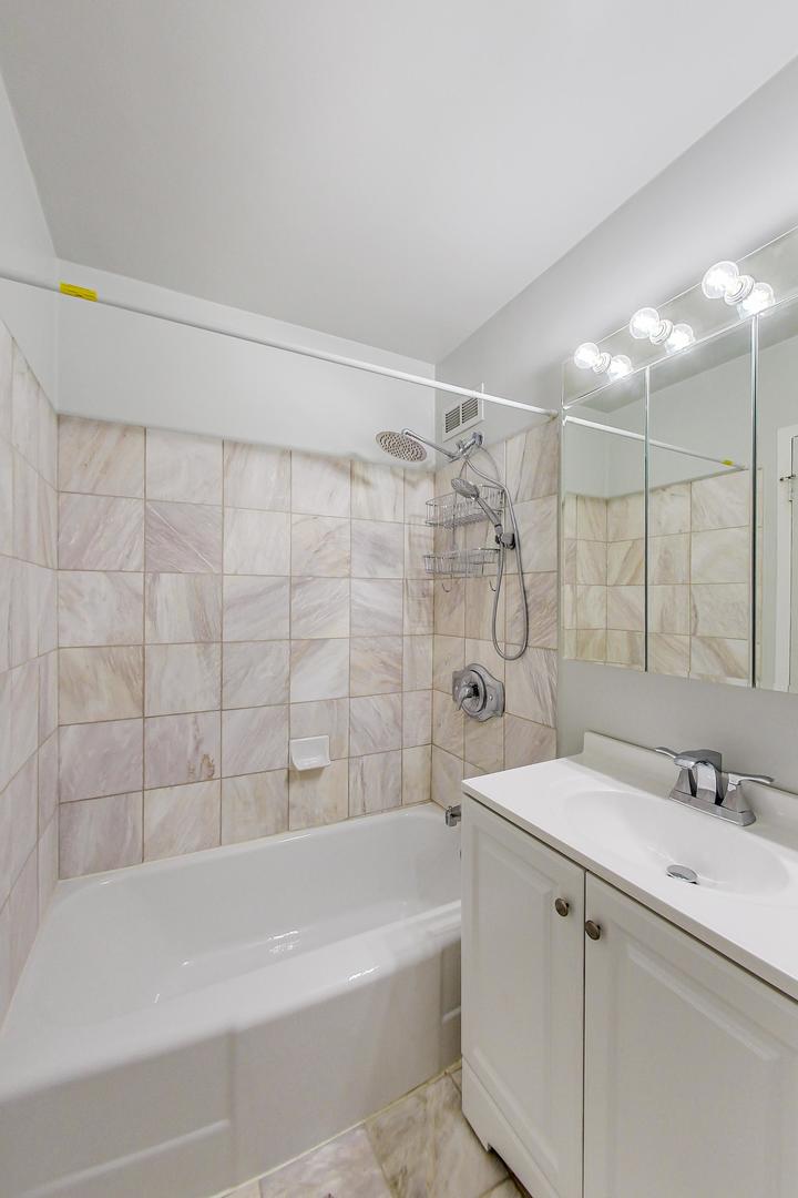 1150 North Lake Shore Drive, Unit 11J Chicago, IL 60611 - Photo 21 of 34 a bathroom with a shower curtain and a sink