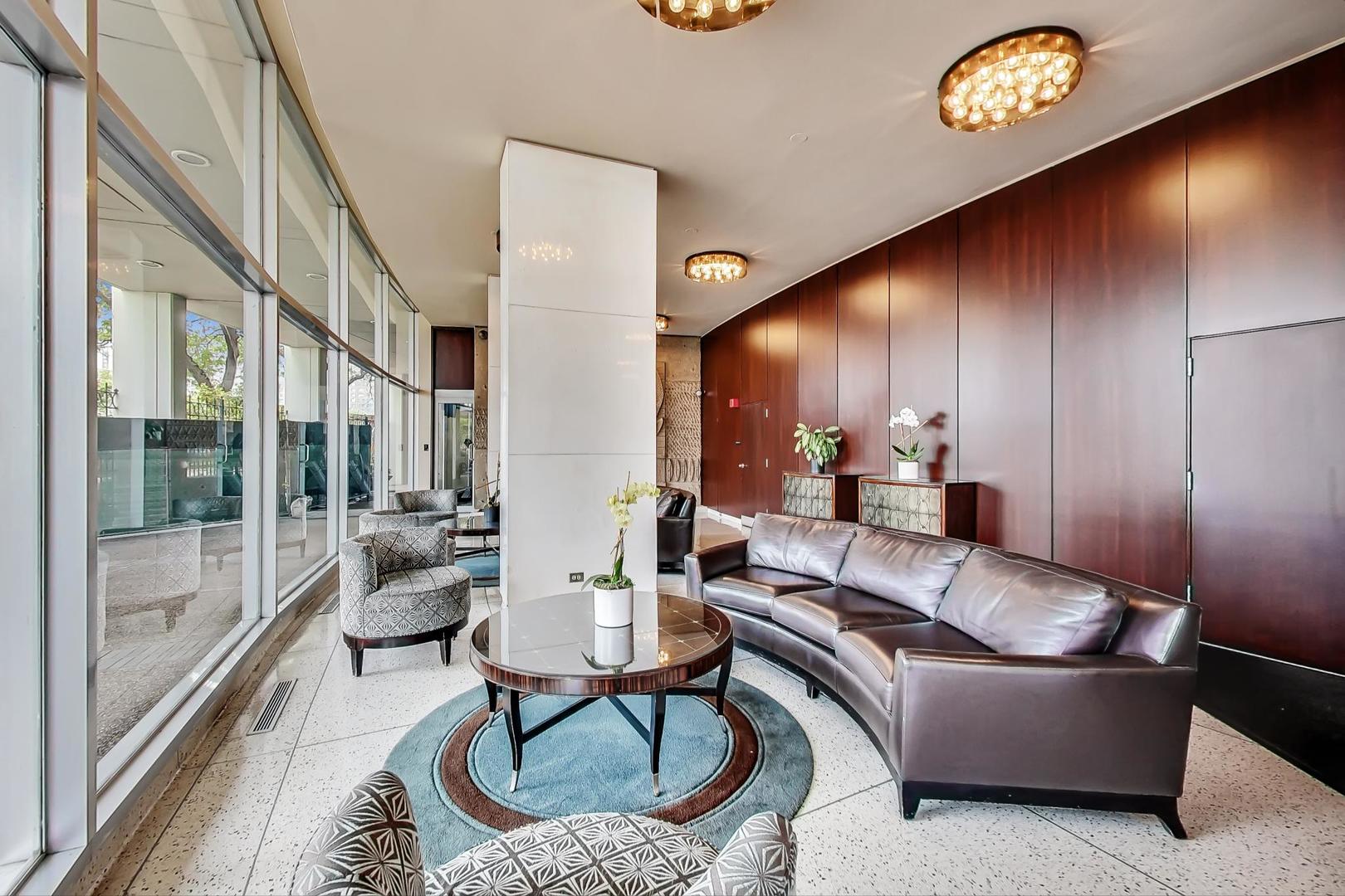 1150 North Lake Shore Drive, Unit 11J Chicago, IL 60611 - Photo 4 of 34 a living room with furniture and a floor to ceiling window