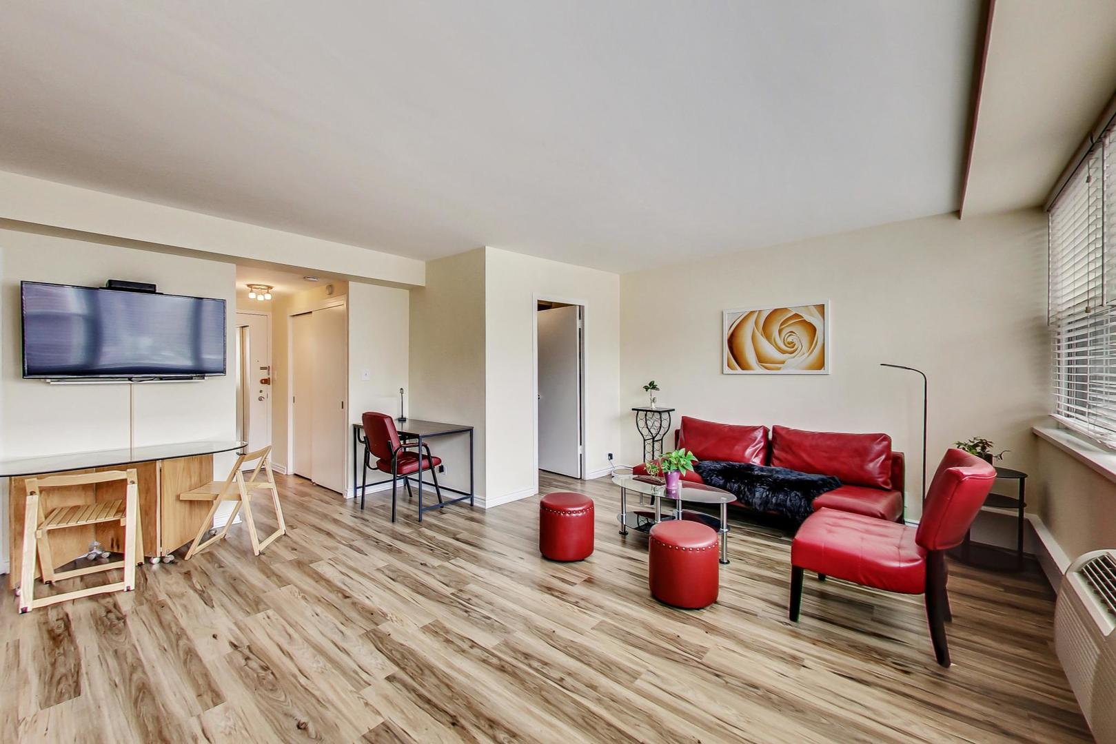 1150 North Lake Shore Drive, Unit 11J Chicago, IL 60611 - Photo 8 of 34 a living room with furniture kitchen view and a wooden floor