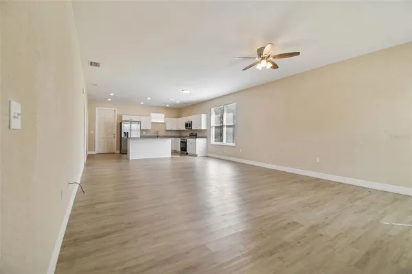 a view of a livingroom with a hardwood floor and a ceiling fan
