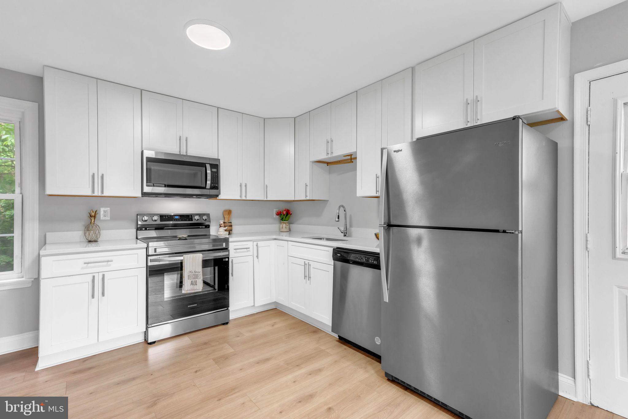 7400 Jaffrey Road Fort Washington, MD 20744 - Photo 14 of 31 a kitchen with white cabinets and stainless steel appliances