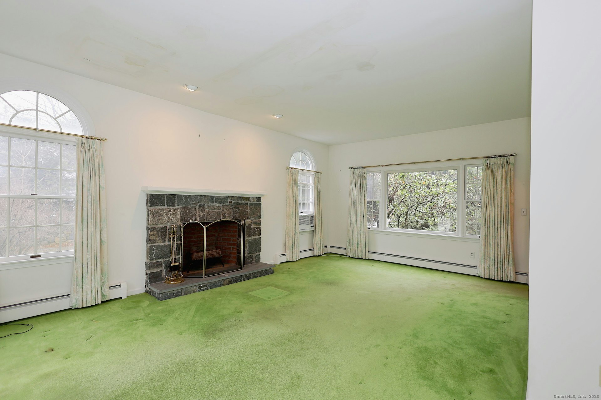 1213 Cedar Road Fairfield, CT 06890 - Photo 7 of 40 a view of an empty room with a fireplace and a window