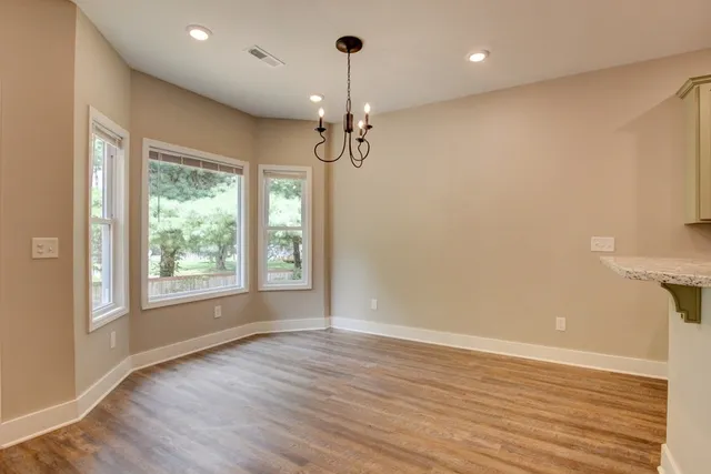 an empty room with wooden floor and a ceiling fan