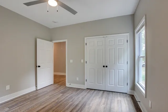 an empty room with wooden floor and windows