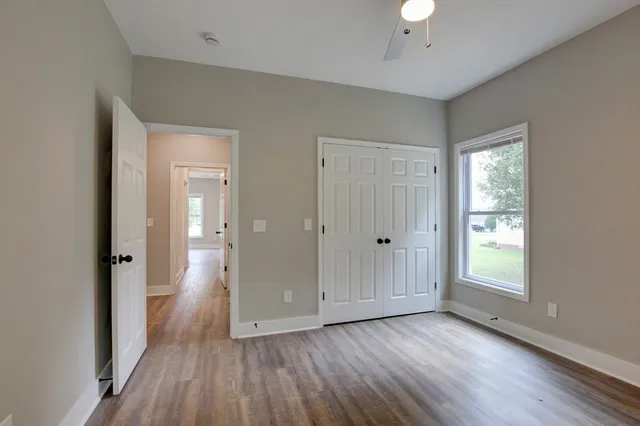 an empty room with wooden floor and windows