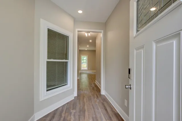 a view of a hallway with wooden floor and staircase