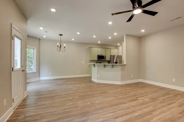 a view of an empty room with window and wooden floor