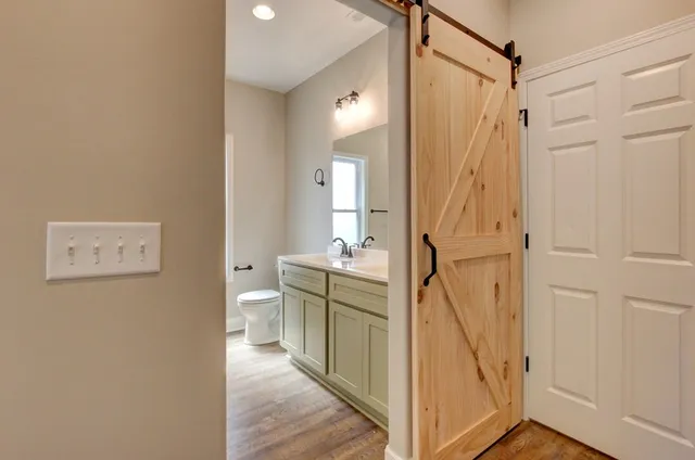 an empty room with wooden floor and a ceiling fan