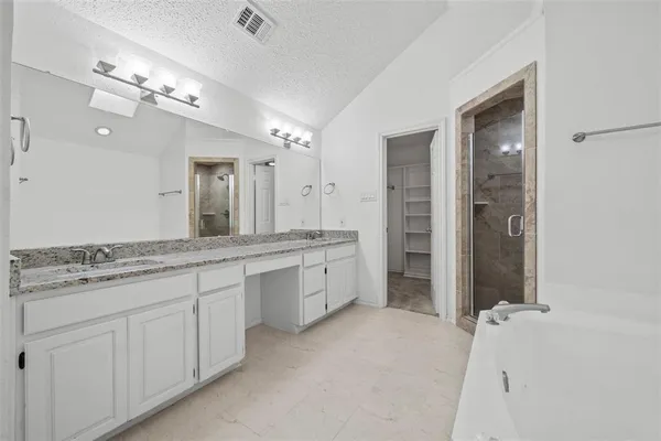 a spacious bathroom with a granite countertop sink a toilet a mirror and shower