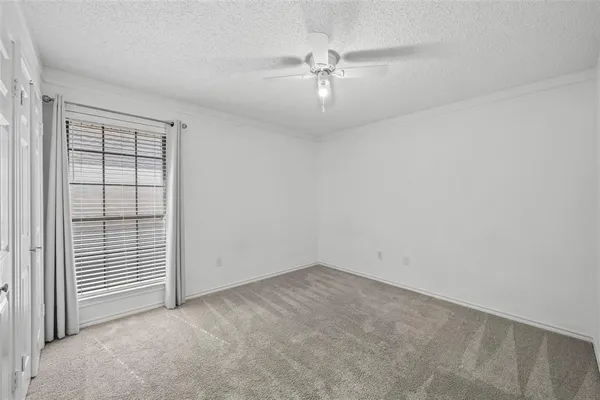 an empty room with chandelier fan