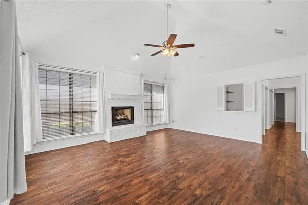 a view of empty room with wooden floor and fireplace