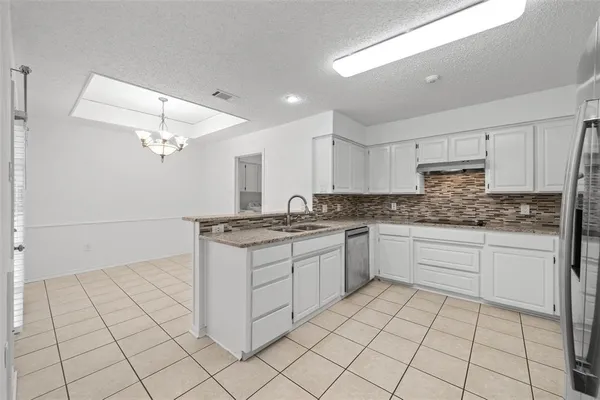 a kitchen with granite countertop white cabinets and white appliances