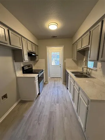 a kitchen with a sink a counter top space stainless steel appliances and a window
