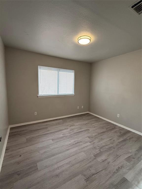 1435 North Bluegrove Road Lancaster, TX 75134 - Photo 6 of 9 an empty room with wooden floor and windows