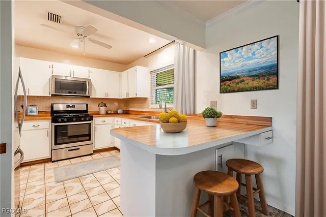 a kitchen with stainless steel appliances a stove a sink dishwasher and a refrigerator with wooden floor