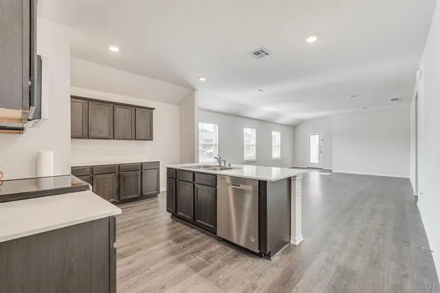 a large kitchen with stainless steel appliances cabinets and wooden floor