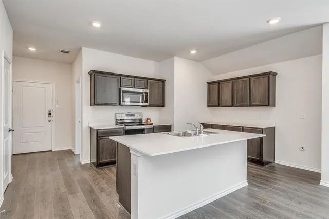 a kitchen with a sink stainless steel appliances and white cabinets