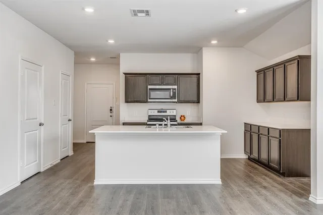 a view of kitchen with stainless steel appliances cabinets and wooden floor