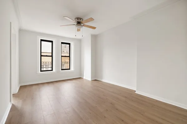 a kitchen with a refrigerator a stove top oven a white counter space and wooden floor